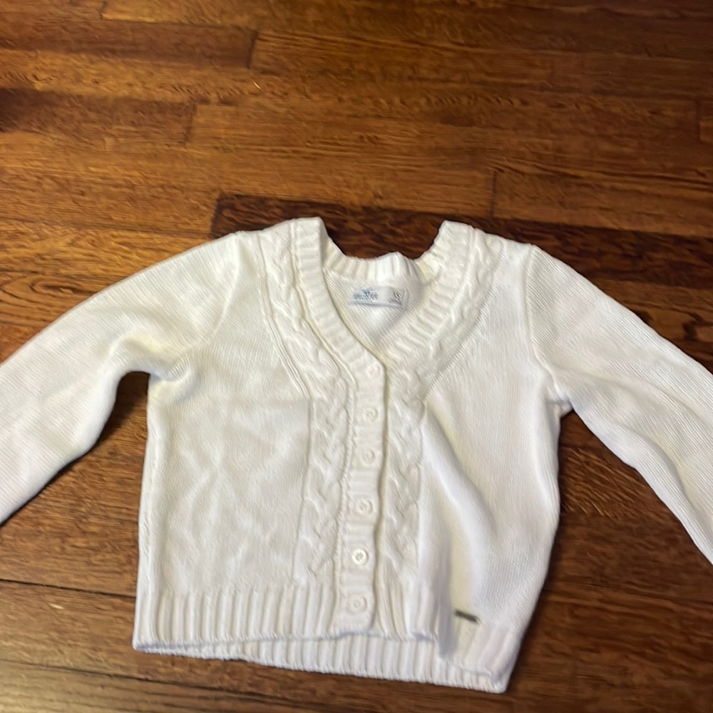 a white designed button up sweater